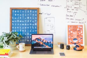 Macbook pro on desk in front of whiteboard